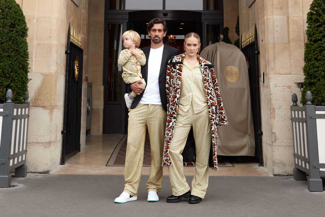 A stylish family stands outside Rosewood Hôtel de Crillon entrance, in Paris.